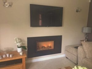 A Fireplace in a living room below a TV